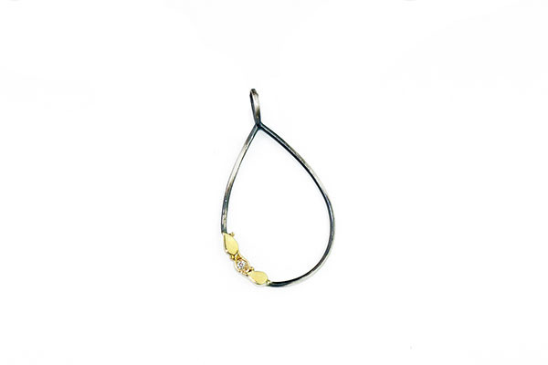 Colgante de plata oxidada con motivo en oro amarillo y un brillante blanco.