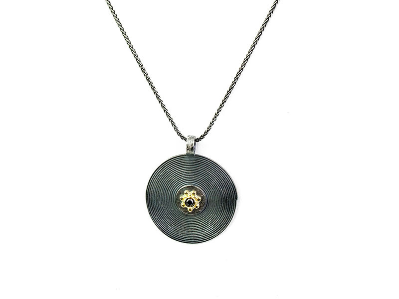 Oxidized silver and 750 mm yellow gold pendant with black diamond. Oxidized silver and 750 mm yellow gold pendant with black diamond.