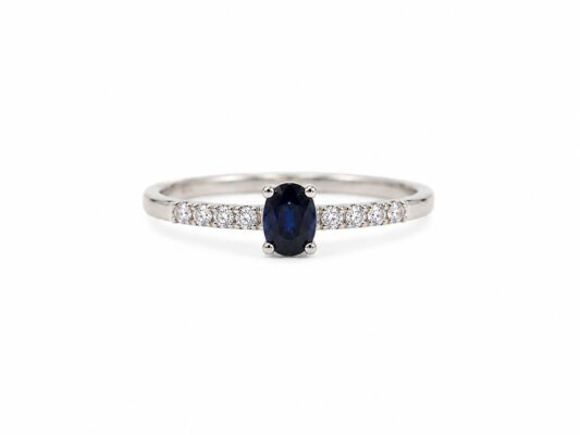 Anell d'or blanc amb safir blau oval i brillants.